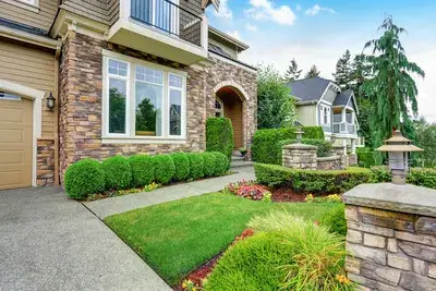 Beautiful front yard eco-friendly landscaping in Lisle, IL, with well-maintained shrubs and a stone pathway for a low-maintenance outdoor space.